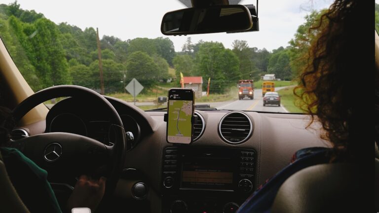 Uma Mulher Dirigindo Um Carro Com Um Celular Na Mao oHACdhkVrTo