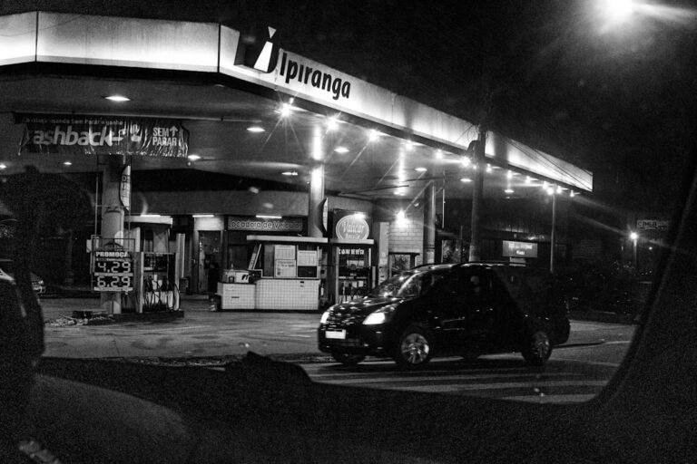 Um Carro Em Um Posto De Gasolina Bem Iluminado a Noite h22Y47fu_Wg