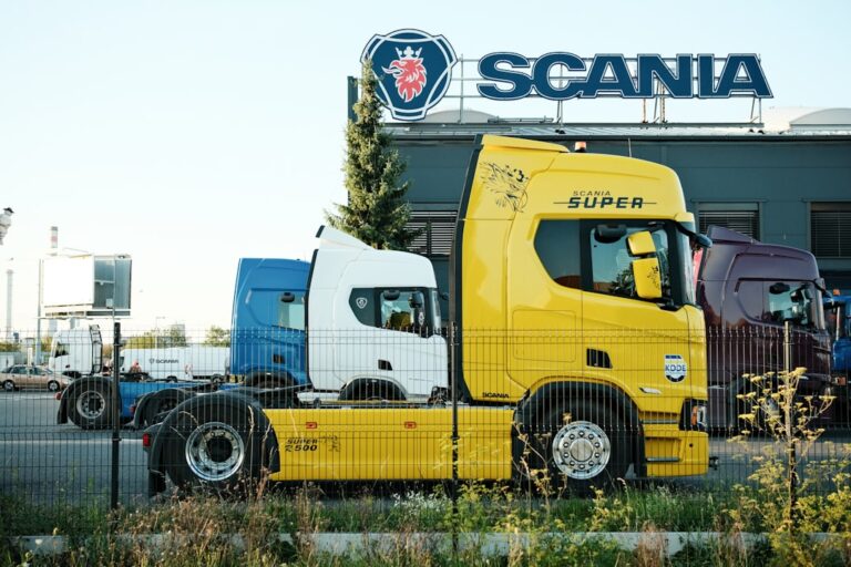 Caminhoes Amarelos E Azuis Estacionados Fora Da Construcao Da Scania SWQj60GzTzE