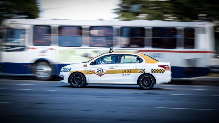A yellow and white taxi speeding through Montevideo city streets, captured with motion blur effect.