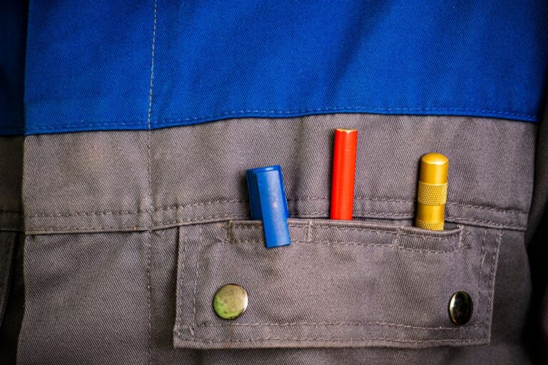 Close-up of colorful tools in a blue and gray workwear pocket.