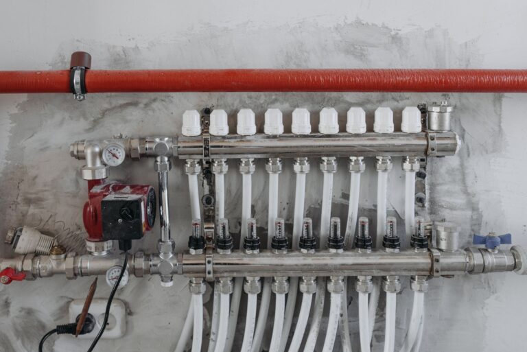 A close-up view of an industrial manifold with pressure gauges and connected steel pipes.