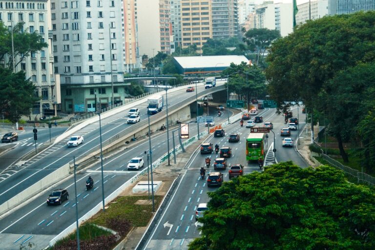 An overhead view showcasing the bustling traffic on a São Paulo highway amid green urban surroundings.