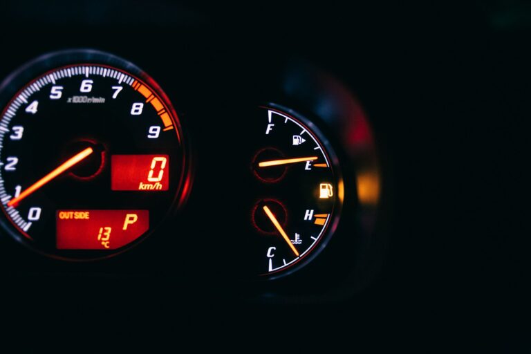 Modern control and measuring devices with arrows indicating numbers and letters on scales in automobile on black background