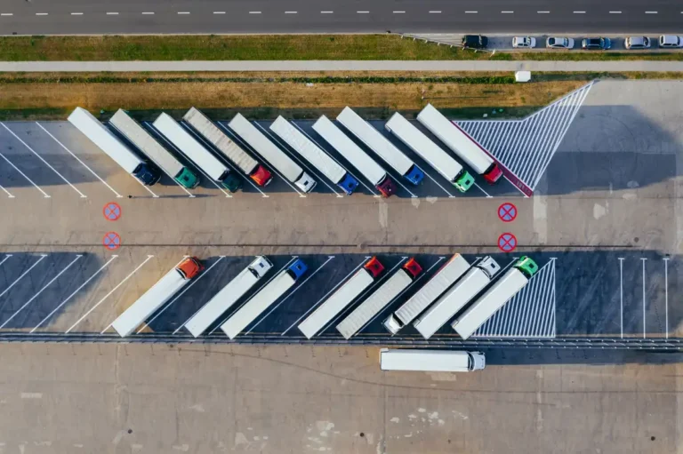 Overhead shot of semi-trucks parked in Poznań, Poland, demonstrating transportation logistics.