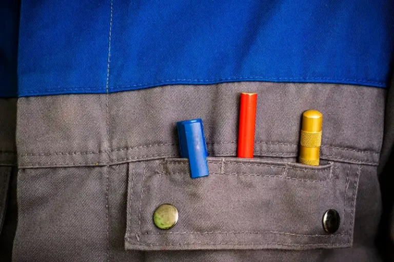 Close-up of colorful tools in a blue and gray workwear pocket.